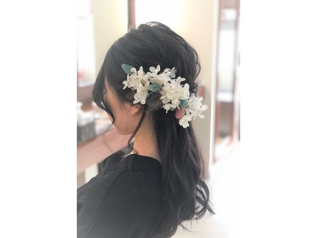 生花の髪飾りを添えたブライダルヘア